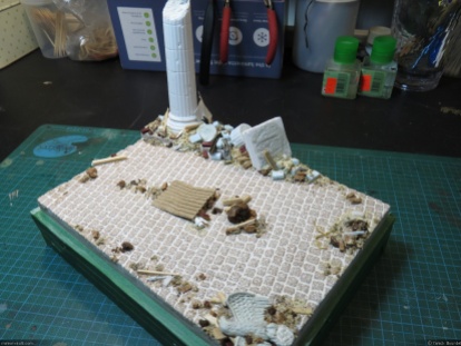 Various debris are then glued to the base using white glue and wood filler.